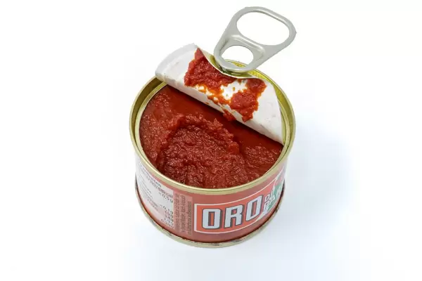 Oro Tomatenmark in einer kleinen offenen Dose auf weißem Hintergrund