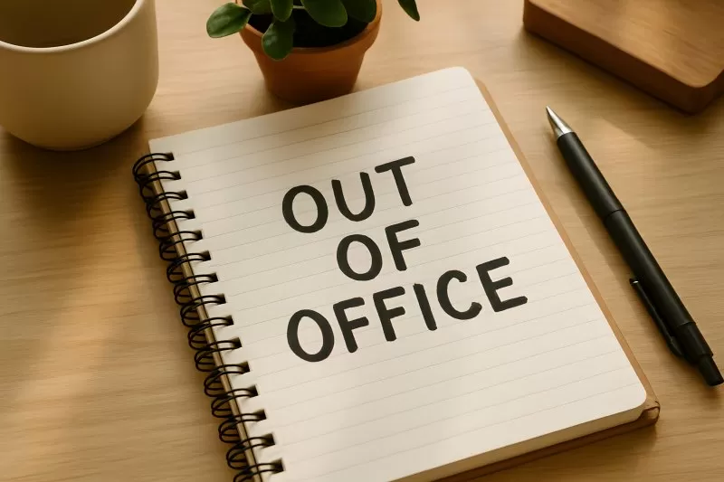Out of Office Notiz auf Schreibtisch mit Stift