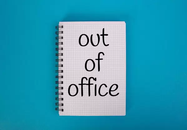 Out of office text written in notebook
