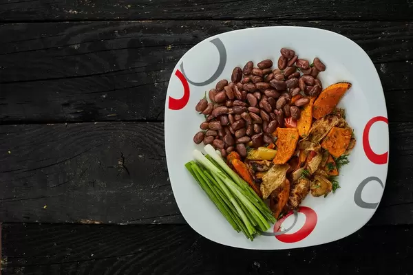 Oven-cooked vegetables garnished with boiled red kidney beans and scallions