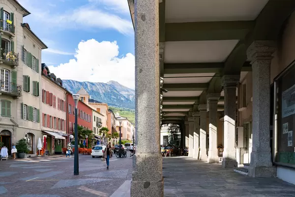 Overhanging passage on the right side and colorful Sion street with picturesque mountains on the left