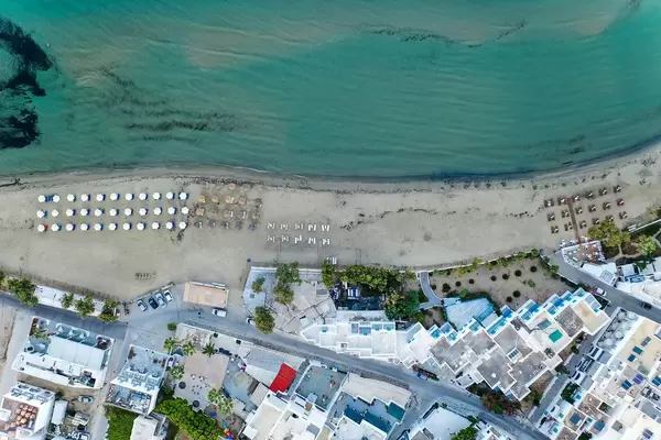 Overhead drone shot of the Agios Georgios (Saint George) beach of Chora, Naxos, with shallow waters