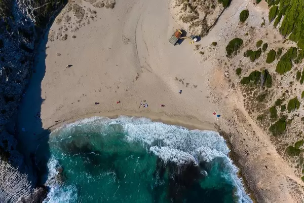 Overhead drone shot of waves hitting the shore at Cala Torta beach, north-east coast of Mallorca