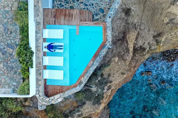 Overhead drone shot taken while relaxing by the pool with cliff and sea view. Iliada Suites hotel, Naxos