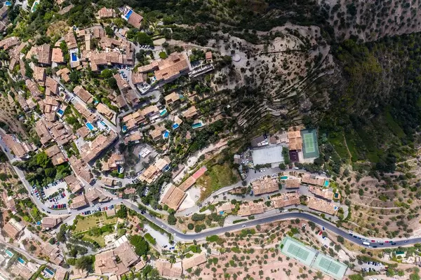 Overhead-Luftaufnahme der Dächer von Deià auf Mallorca. Häuser mit Pool mitten im Grünen