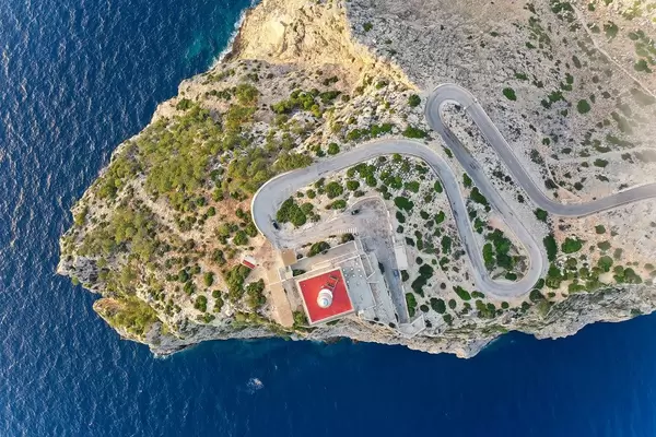 Overhead Luftbild: der weiß-rote Leuchtturm vom Cap de Formentor, die Steilküste und das blaue Meer