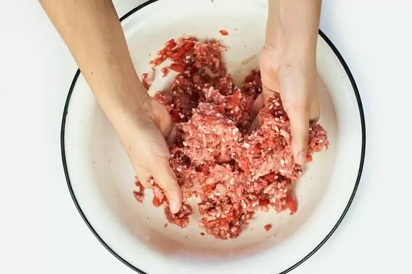 Overhead view of a woman preparing dinner with stuffed meat and rice