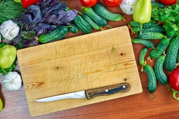 Overhead view of raw vegetables - tomatoes, cucumbers, purple basil, garlic, bell peppers and green herbs