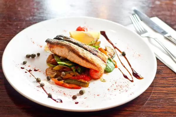 Overview of plate of delicious fish with vegetables at a fancy restaurant