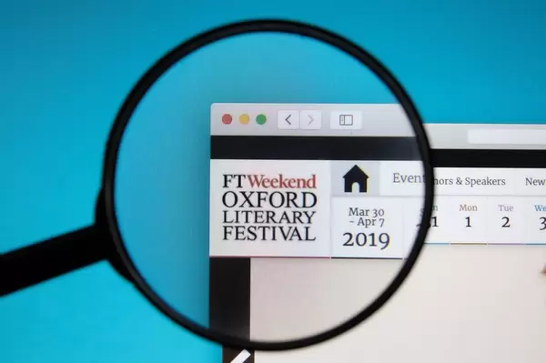 Oxford Literary Festival website on a computer screen with a magnifying glass