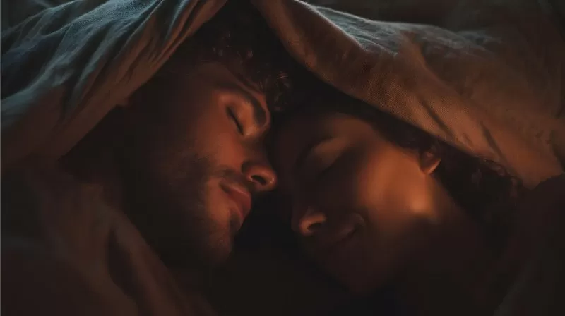 Paar schläft gemeinsam unter warmer Decke