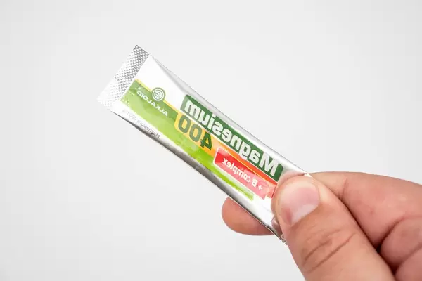 Package of Magnesium powder in the hand above white background (Flip 2020)