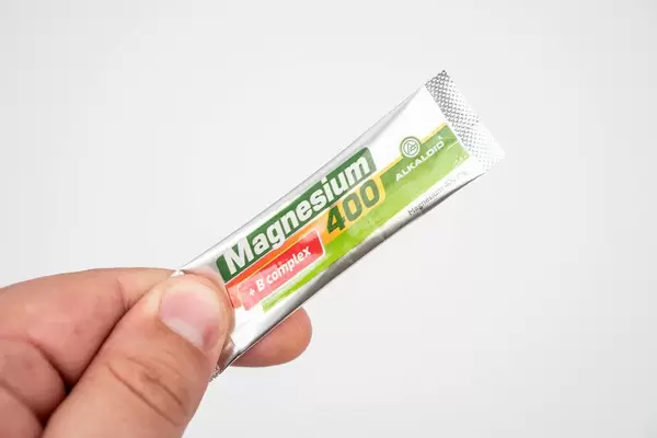 Package of Magnesium powder in the hand above white background