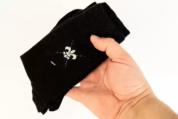 Packed Black Socks in the hand above white background (Flip 2019)