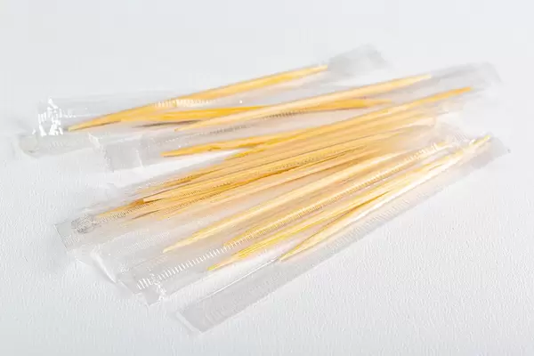 Packed wooden toothpicks on white background