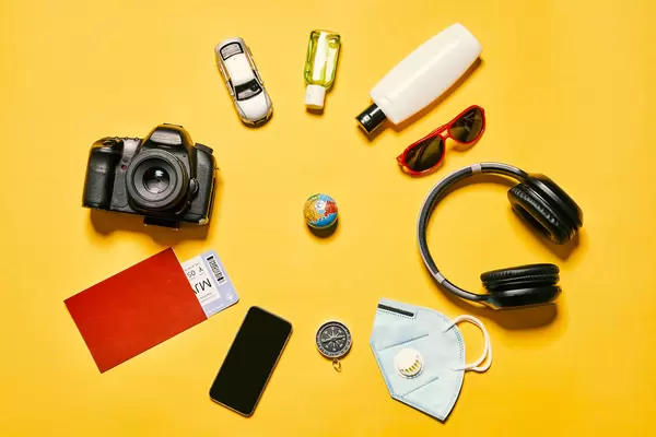 Packing backpack for a trip concept with traveler items on yellow background