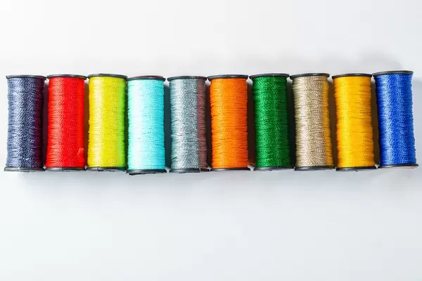 Palette of colored threads on white background