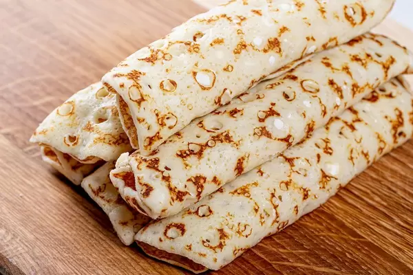 Pancakes with filling wrapped to the tube on a wooden kitchen Board