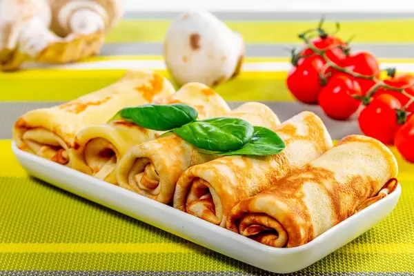 Pancakes with mushrooms and tomatoes on the table (Flip 2019)