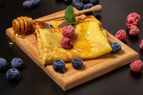 Pancakes with raspberries, blueberries and honey