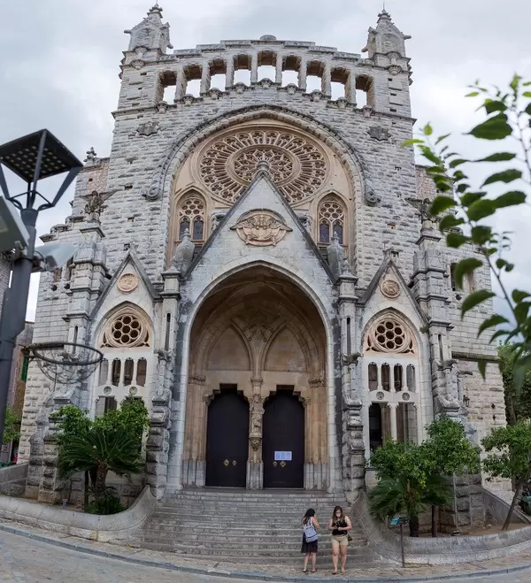Panoramic photo of the modernist facade of St Bartholomew's church in the main square of Sóller