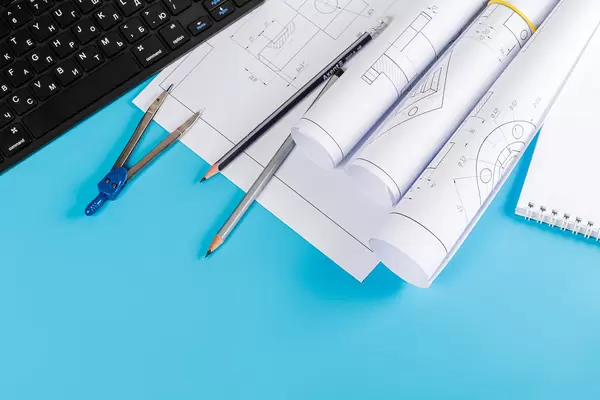 Paper engineering drawings on blue background