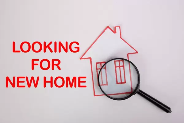 Papier-Haus mit roter Umrandung auf weißem Hintergrund & Text "looking for new home" - Suche nach einem neuen Zuhause