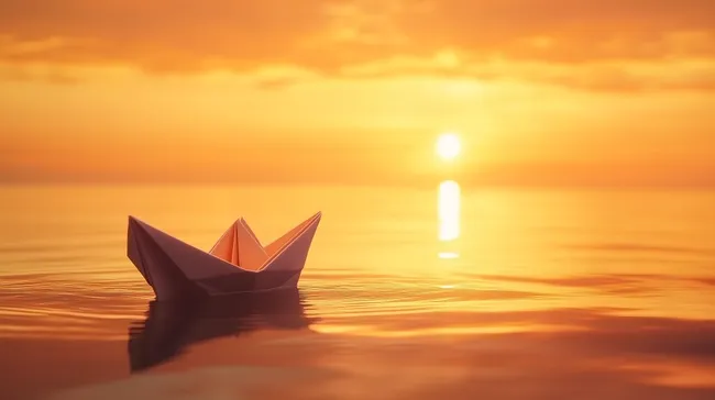 Papierboot auf ruhiger Meeresoberfläche bei Sonnenuntergang