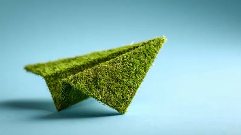 Papierflieger aus dichtem Rasen auf blauem Hintergrund