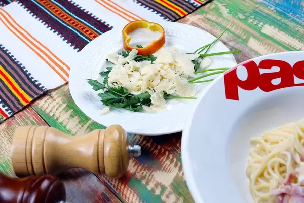 Parmesan cheese slices and carbonara spaghetti, italian cuisine