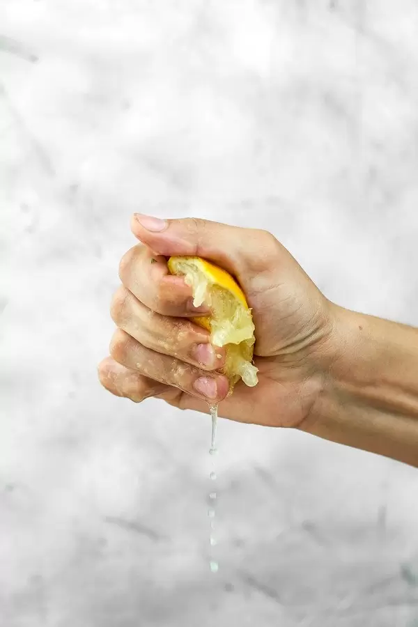 Partial view of woman hand squeezing fresh lemon