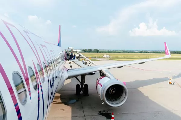 Passagiere steigen in ein WizzAir Flugzeug