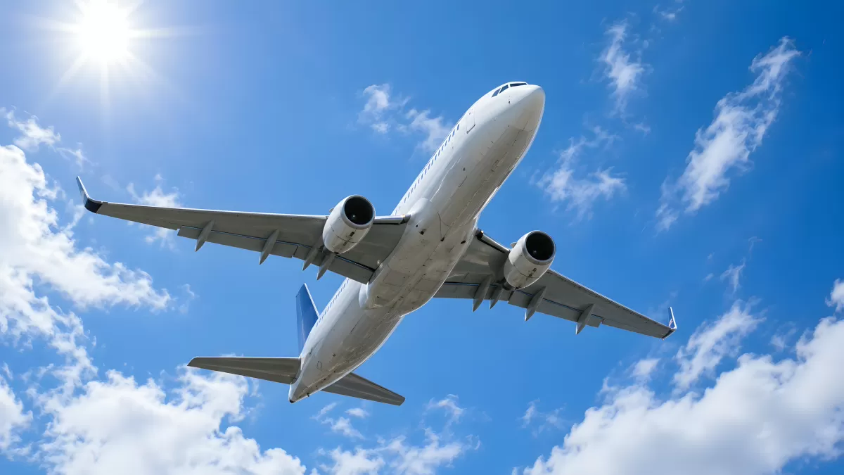 Passagierflugzeug von unten vor blauem Himmel