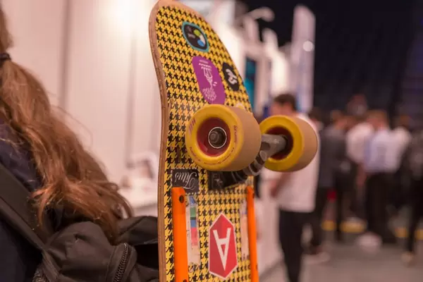 Passant mit einem bunten Skateboard am Rücksack