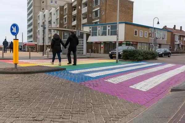 Passanten gehen über Fußgängerstreifen in Regenbogenfarben in Zandvoort, Niederlande