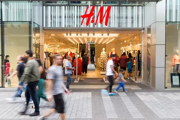 Passanten laufen an einer H&M Filiale vorbei