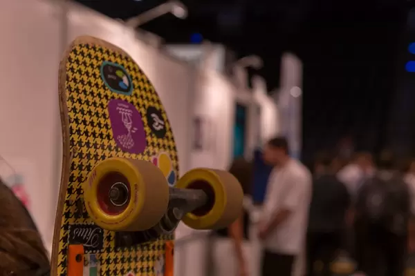 Passerby with a colorful skateboard tied to his backpack