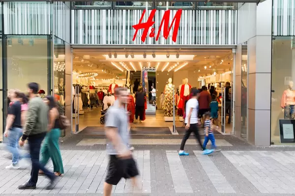 Passersby walking by an H&M outlet