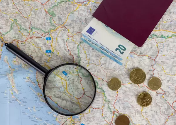 Passport and magnifying glass on map