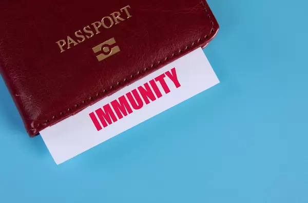 Passport with Immunity card on blue background