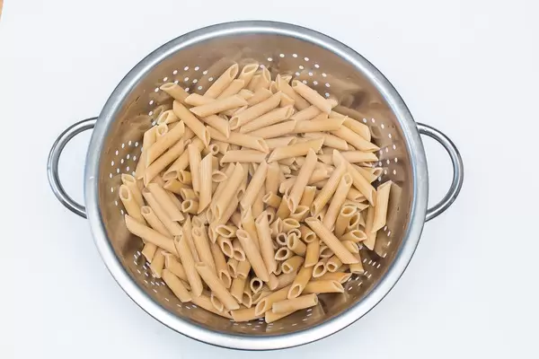 Pasta in a Colander on a White Background