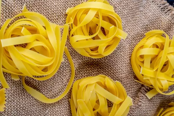 Pasta in the shape of a nest on the background of burlap
