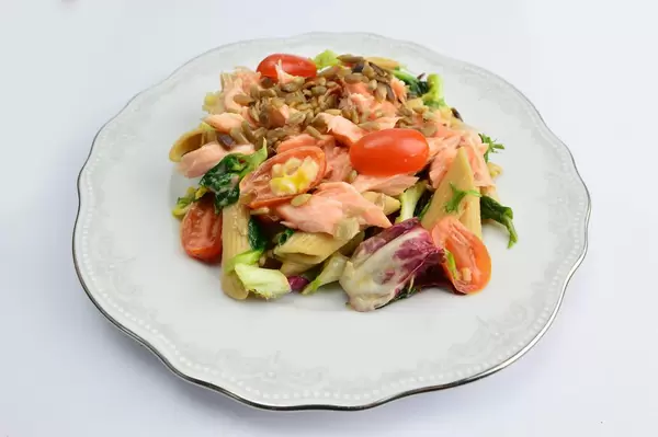 Pasta with salmon, tomatoes, spinach and sunflower seeds