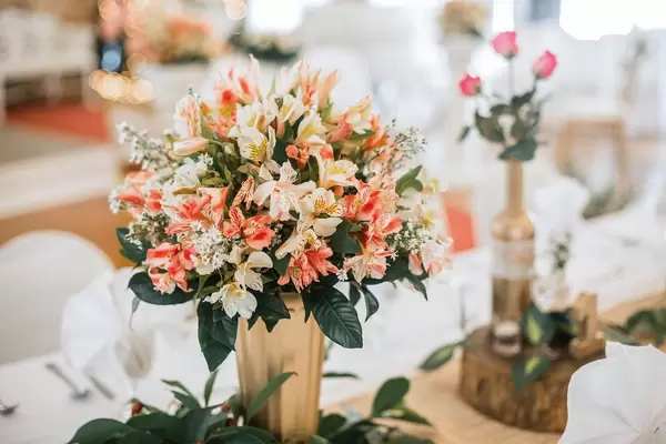 Pastellfarbener Blumenstrauß in goldener Vase dekoriert Tisch bei Hochzeit
