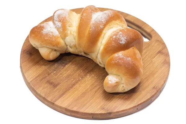 Pastry roll with powdered sugar on the round wooden board