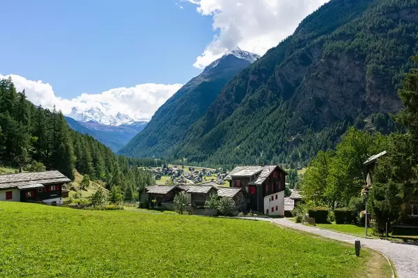 Path descending from mountains to a Swiss valley with a village