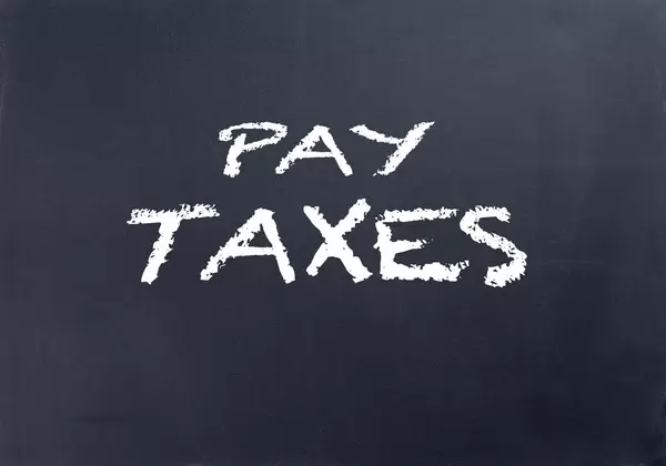 Pay taxes text on blackboard