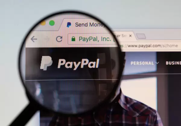 PayPal-Logo am PC-Monitor, durch eine Lupe fotografiert