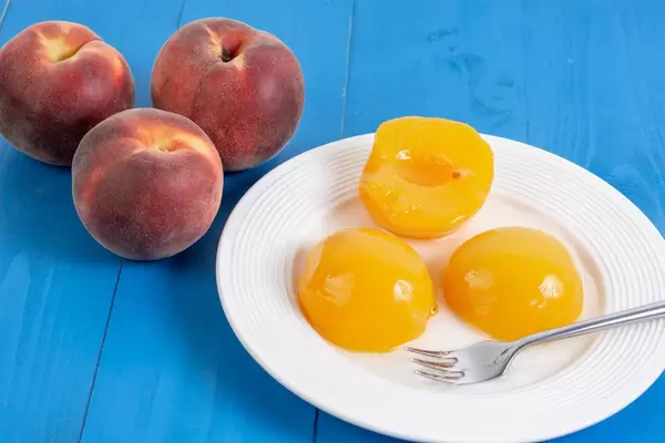 Peach Compote on the plate with fresh Peaches