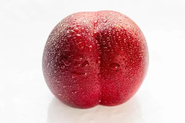 Peach nectarine with water drops on a white plate (Flip 2019) (Flip 2019)